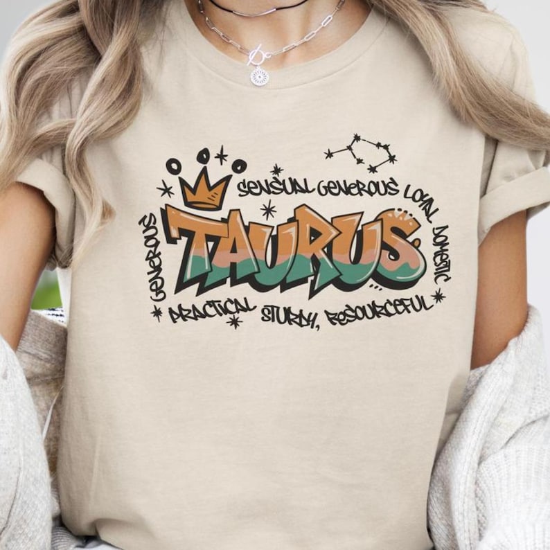 a woman wearing a tan tshirt with the word taurus printed on it