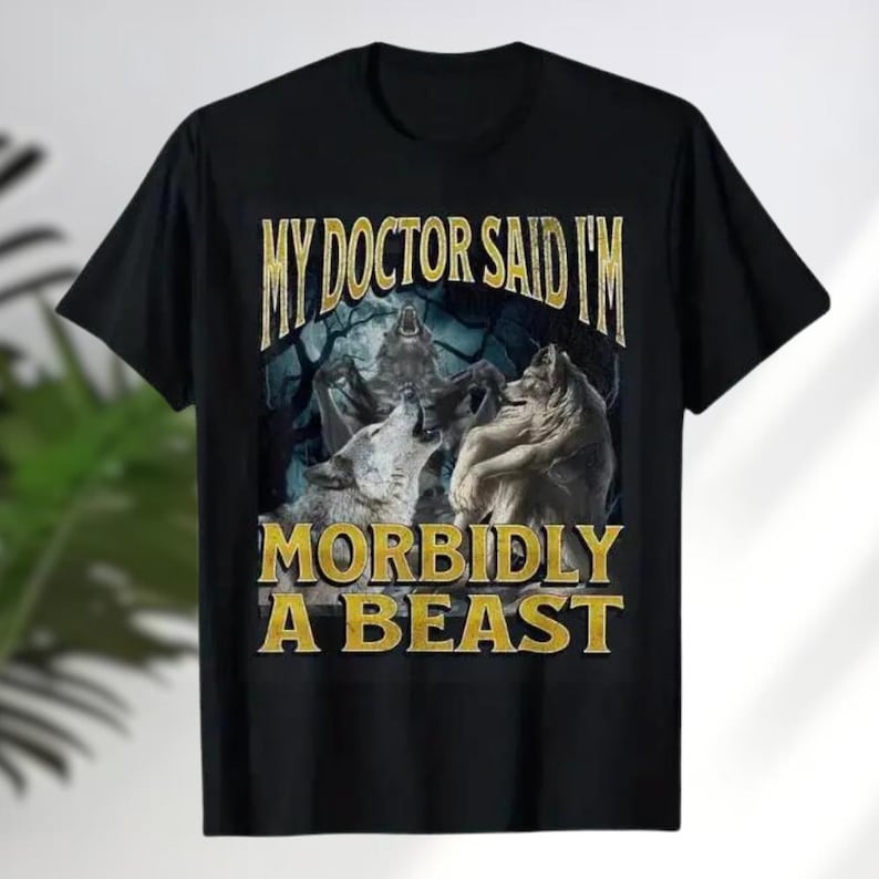a black t-shirt with a graphic design depicting two wolves and the text "MY DOCTOR SAID I'M MORBIDLY A BEAST" printed on it.
