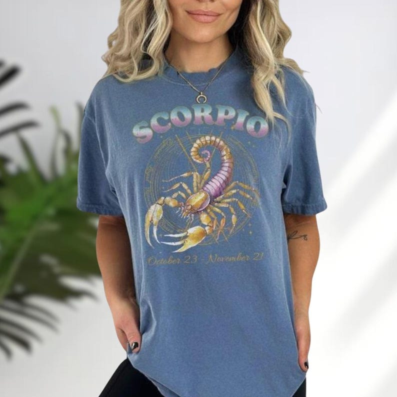 a woman with blonde hair wearing a scorpion t - shirt