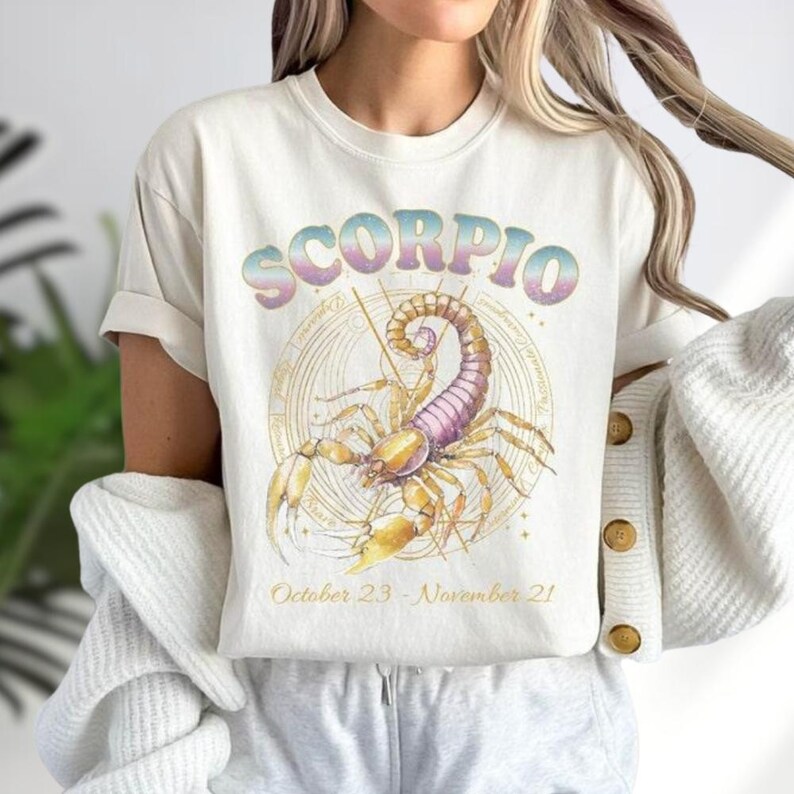 a woman wearing a white scorpion t - shirt