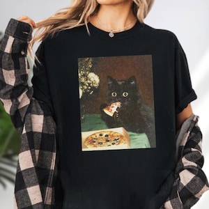 A black cat is depicted eating a slice of pizza in the image.