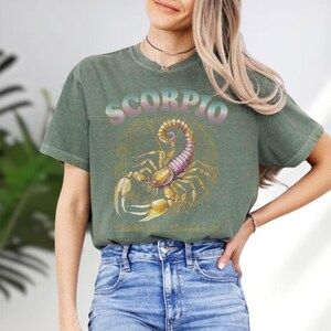 a woman wearing a scorpion t - shirt and jeans