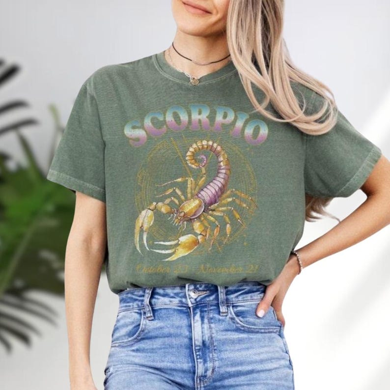 a woman wearing a scorpion t - shirt and jeans