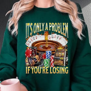 a woman in a green sweatshirt holding a cup of coffee