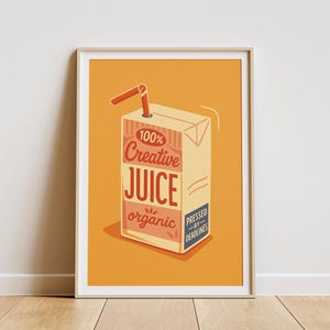 以下が含まれることがあります： ジュースの箱のデザインが施された、額装されたアートプリント。ベージュのジュースの箱には、赤色の文字で「100% Creative Juice organic」と「Pressed by Deadlines」と書かれています。赤いストローが挿入されています。背景はオレンジ色です。
