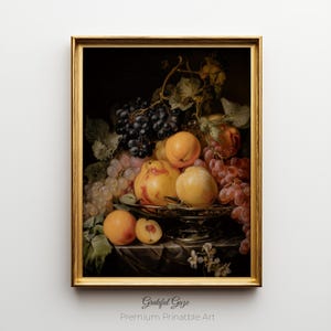May include: A framed still life print featuring a golden frame. The artwork depicts a bountiful arrangement of fruits, including grapes, peaches, and apricots, arranged on a decorative silver dish. The text "Grateful Gaze Premium Printable Art" is at the bottom.