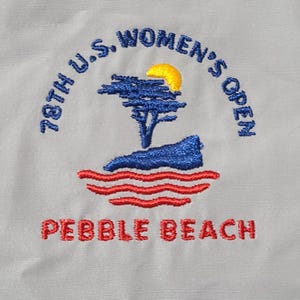 May include: Embroidered patch featuring the 78th U.S. Women's Open at Pebble Beach. The design includes a blue tree, a yellow sun, blue water, and red waves. The text "PEBBLE BEACH" is in red.