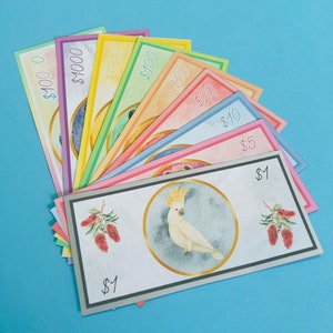 Può includere: Un set di banconote giocattolo colorate con animali selvatici australiani, tra cui un cacatua, con tagli che vanno da $ 1 a $ 10.000.