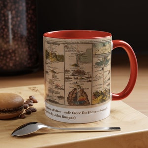 May include: A red and white ceramic mug with a vintage illustration of a map. The mug features the text "A place of bliss - safe there for those who walk" and "Progress by John Bunyan".