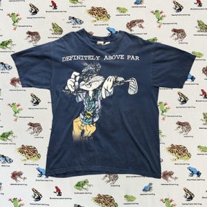 Camiseta azul marino con dibujos animados de golf de los 90, Looney Tunes, Bugs Bunny, "Definitivamente por encima de la media" y Warner Bros., Merrie Melodies.
