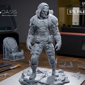 May include: A gray 3D printed resin figurine of a hooded character with horns, wearing tactical gear, a utility belt, and armored pants, standing on a rocky base. The image includes the text OASIS Digital Sculpting Sanctuary and STL FILE.