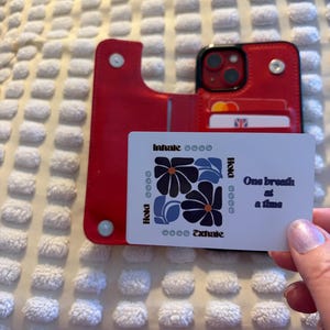 以下が含まれることがあります： 黒い持ち手と「But First, Coffee」のテキストが黒い太字で書かれた白いセラミックマグ。マグは木製の表面に置かれています。マグの高さは約10cmです。