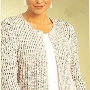 Puede incluir: Un cárdigan de punto de color crema con un frente ligeramente abierto y mangas largas. El cárdigan está hecho de un hilo texturizado y tiene un diseño simple y clásico.