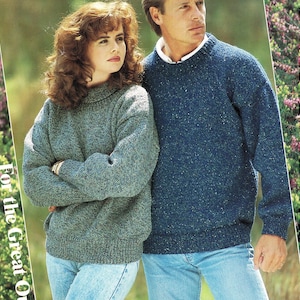 May include: Two people in knitted sweaters and blue jeans. The woman wears a grey turtleneck sweater, the man a blue crew neck. The background is a blurred outdoor scene. The image has a vintage aesthetic.