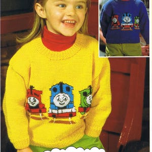 May include: A child in a yellow knitted jumper featuring Thomas the Tank Engine and friends. The design includes three colourful train characters. The image also shows the text "THOMAS THE TANK ENGINE & FRIENDS".