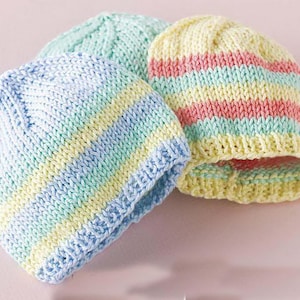 May include: Three knitted hats in different colors: light blue with yellow and green stripes, light pink with yellow and green stripes, and green with yellow stripes.