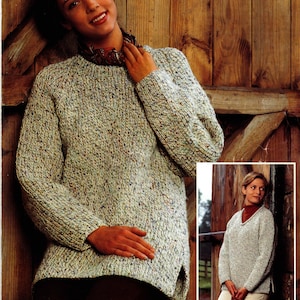 Könnte beinhalten: Eine Frau trägt einen hellgrauen Strickpullover mit blauen, braunen und grünen Flecken. Der Pullover hat einen Rundhalsausschnitt und lange Ärmel. Ein kleineres Bild zeigt einen ähnlichen Pullover mit V-Ausschnitt.