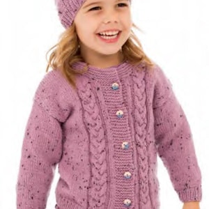 May include: A knitted lavender hat and cardigan set for a child. The cardigan features a cable knit design and button closure. The set is made of a speckled yarn, and the buttons have a floral design.