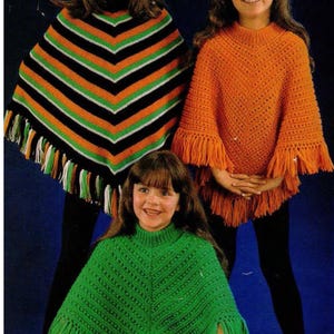 Puede incluir: Tres chicas con ponchos de ganchillo con flecos. Los ponchos son de diferentes colores: rayas negras y naranjas, naranja y verde.