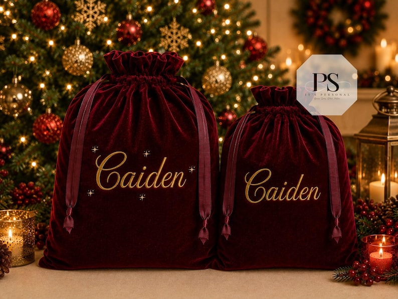May include: Two deep red velvet drawstring bags with a soft, plush texture. Each bag features the name Caiden printed in a gold script font on the front. The larger bag includes small gold star accents around the name, and both bags have matching red ribbon ties at the top.