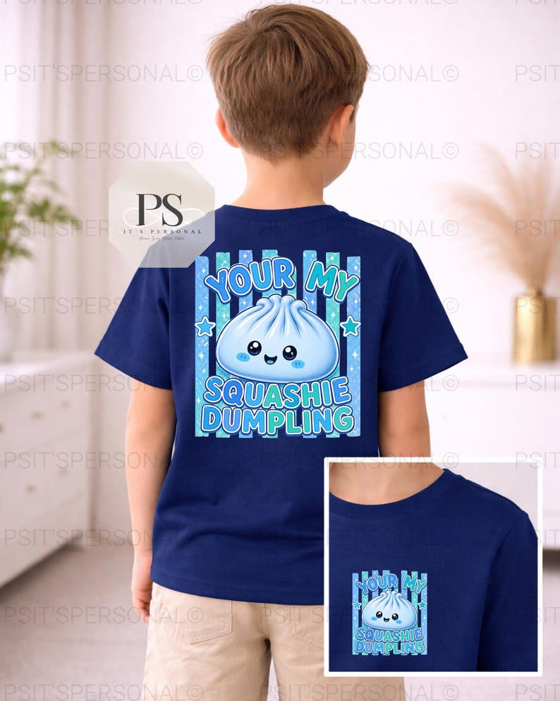 May include: A navy blue t-shirt with a cartoon dumpling design and the text "Your My Squashie Dumpling". The design includes blue stars and vertical stripes. The shirt is worn by a child.