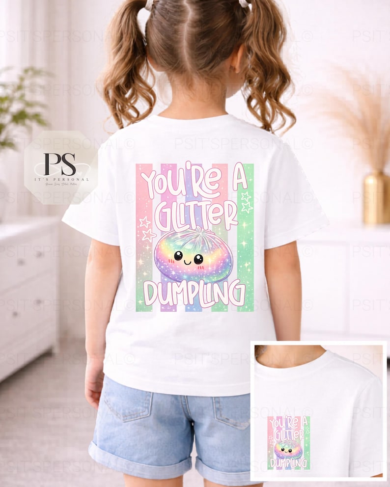 May include: White t-shirt featuring a colourful graphic of a smiling dumpling and the text "You're a Glitter Dumpling". The design includes pastel stripes and stars. The shirt is worn by a child.