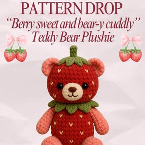 May include: A handmade strawberry-shaped teddy bear plushie. The bear is red with green leaves, pink arms and ears, and a tan snout. The text "PATTERN DROP" and "Berry sweet and bear-y cuddly" are displayed above the bear.