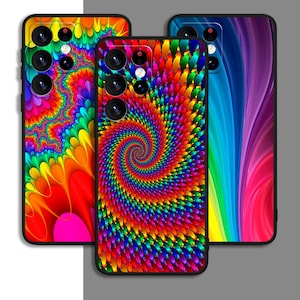 以下が含まれることがあります： 鮮やかなサイケデリックデザインの携帯電話ケース3つ。1つは虹色のスパイラル、もう1つは流れるような虹色のパターン、3つ目はカラフルな抽象的なデザインです。各ケースには黒い縁とカメラアレイがあります。
