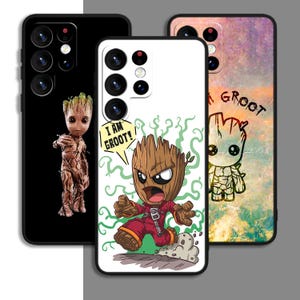 Könnte beinhalten: Drei Handyhüllen mit einem Comic-Charakter aus dem Film Guardians of the Galaxy. Der Charakter ist ein baumartiger Humanoid mit einem roten Overall und den Worten "Ich bin Groot!" in einer Sprechblase. Die Hüllen sind weiß, schwarz und in einem farbenfrohen Aquarelldesign.