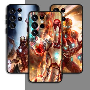Op de afbeelding: Drie telefoonhoesjes met Iron Man-kunstwerken. De hoesjes tonen de superheld in verschillende actieposes tegenover vurige en futuristische achtergronden. De ontwerpen bevatten rode, gouden en blauwe tinten, met gedetailleerde illustraties van het pantser van het personage.