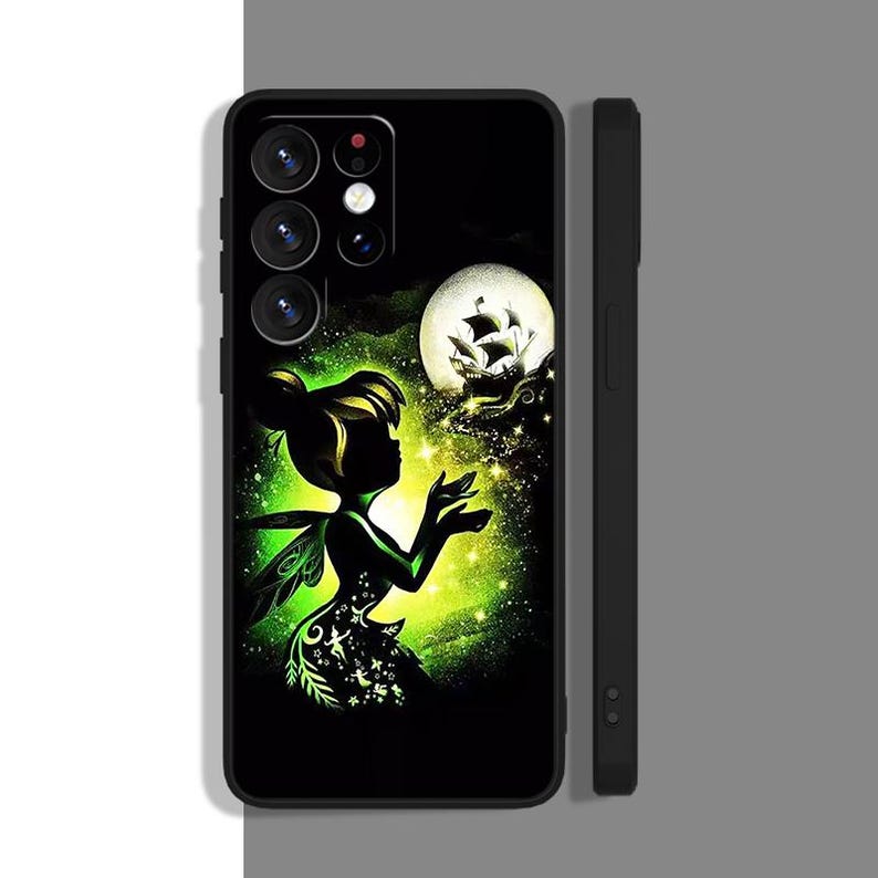 Peut inclure: Une coque de t&eacute;l&eacute;phone noire avec un motif vert, noir et blanc. Le motif repr&eacute;sente une silhouette de la f&eacute;e Clochette avec un navire en arri&egrave;re-plan. La coque de t&eacute;l&eacute;phone a un d&eacute;coupage pour l'appareil photo et un c&ocirc;t&eacute; noir.