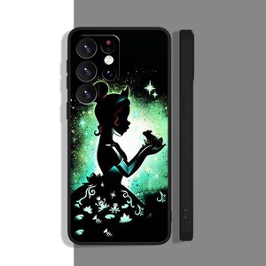 Peut inclure: Une coque de t&eacute;l&eacute;phone noire avec une silhouette d'une princesse et d'une grenouille sur un fond vert et noir. La princesse porte une robe verte et une couronne sur la t&ecirc;te. La grenouille est assise sur sa main. La coque a une d&eacute;coupe pour l'objectif de l'appareil photo.
