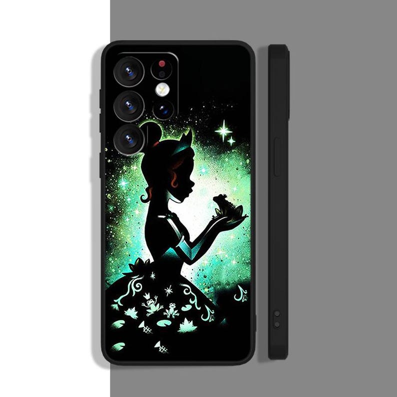 Peut inclure: Une coque de t&eacute;l&eacute;phone noire avec une silhouette d'une princesse et d'une grenouille sur un fond vert et noir. La princesse porte une robe verte et une couronne sur la t&ecirc;te. La grenouille est assise sur sa main. La coque a une d&eacute;coupe pour l'objectif de l'appareil photo.