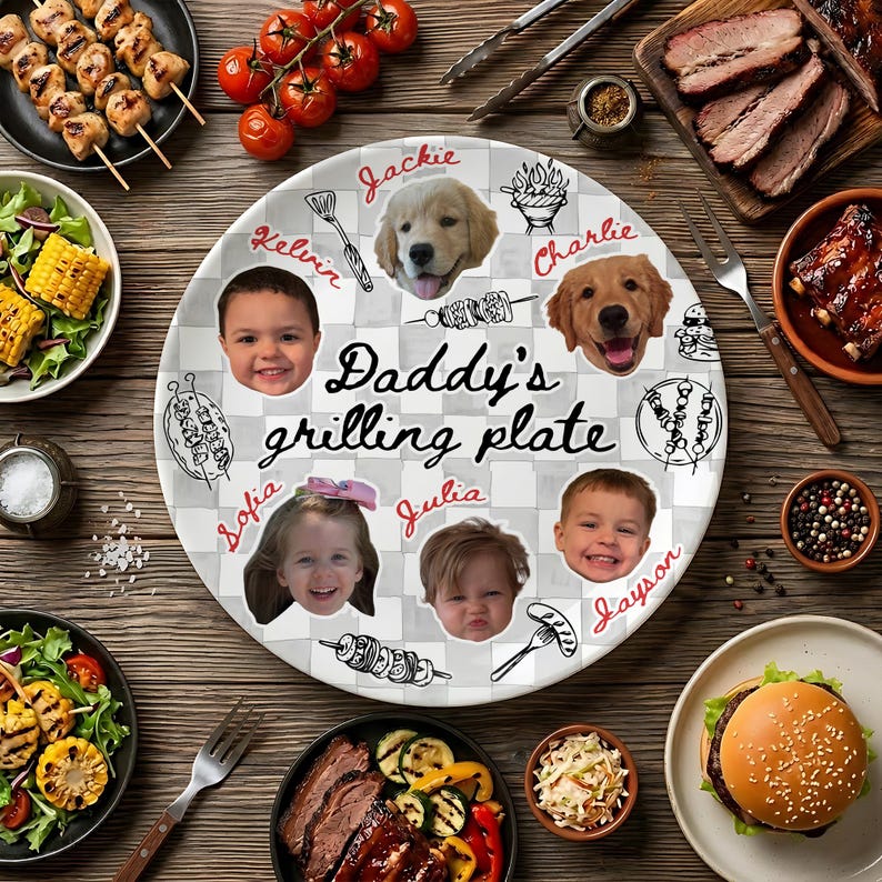 May include: A round white ceramic plate with a gray checkered pattern featuring the text Daddy's grilling plate in the center. The plate displays six circular photo cutouts of two children, two adults, and two golden retriever dogs with names.