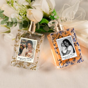 May include: Two rectangular perfume bottles with floral designs and photos. One bottle has a gold floral design, the other has a blue floral design. Each bottle has the text "Forever your little girl, I love you mom."