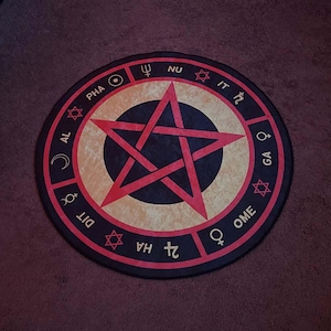Può includere: Tavolo da altare occulto rotondo nero e rosso con un pentagramma rosso al centro, circondato da simboli e testo. Il tavolo ha un cerchio interno beige e un bordo esterno nero. Il testo include le parole: PHA, AL, DIT, HA, OME, GA, NU e IT.