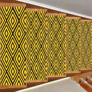 Puede incluir: Cinco paneles de tela con estampado geométrico amarillo y negro. Los paneles están dispuestos horizontalmente y están hechos de un material tejido.