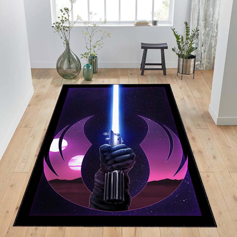 Puede incluir: Una alfombra negra y morada con un dise&ntilde;o de tem&aacute;tica de Star Wars. La alfombra presenta un sable de luz con una hoja azul y un s&iacute;mbolo de la Alianza Rebelde.