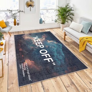 May include: A gray and blue rug with a white cloud design and the text "KEEP OFF" printed on it. The rug is designed by Virgil Abloh for IKEA.