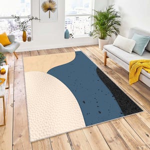 May include: Abstract area rug with a blue, beige, and black geometric design. The rug has a speckled texture.