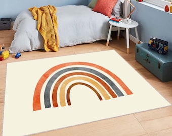 May include: A cream-colored rug with a colorful rainbow design. The rainbow is made up of red, orange, yellow, brown, gray, and blue stripes.
