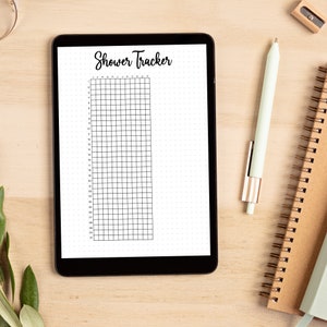 Puede incluir: Una tableta digital que muestra un rastreador de duchas en blanco y negro con una cuadr&iacute;cula y el texto "Shower Tracker" en la parte superior. Los meses del a&ntilde;o est&aacute;n listados en la parte superior de la cuadr&iacute;cula.