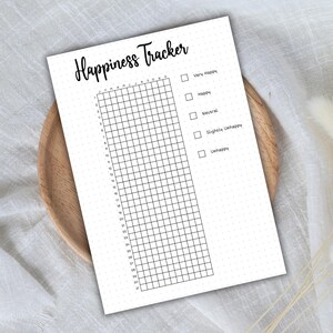 May include: A black and white printable happiness tracker with a grid of 31 days and a checklist of mood options: Very Happy, Happy, Neutral, Slightly Unhappy, Unhappy.