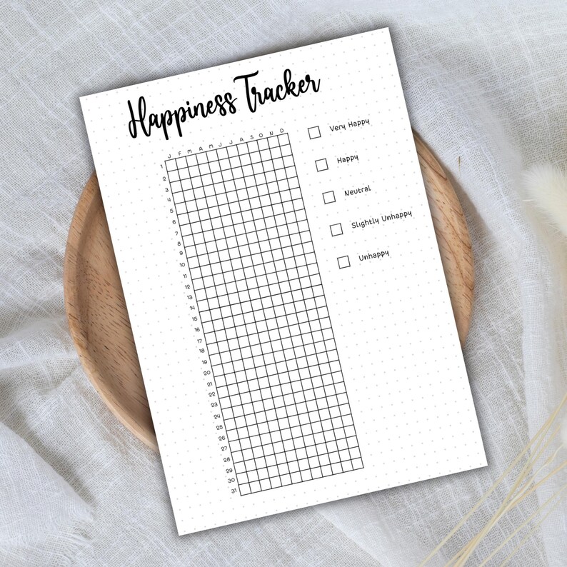 May include: A black and white printable happiness tracker with a grid of 31 days and a checklist of mood options: Very Happy, Happy, Neutral, Slightly Unhappy, Unhappy.