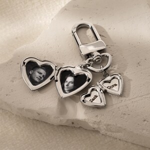 a couple of heart shaped key chains with a picture on them