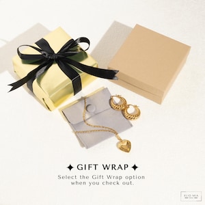 a gift wrapper with a gold heart and a black ribbon
