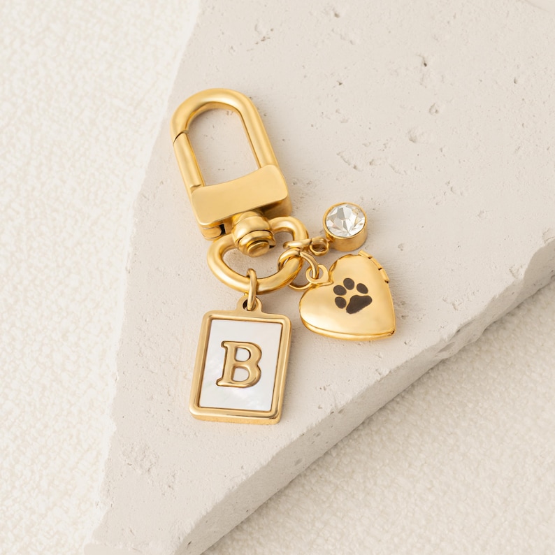 a gold key chain with a dog's paw and heart charm