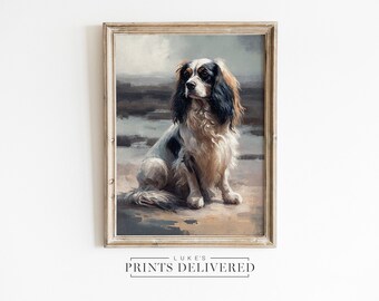 May include: A framed painting of a Cavalier King Charles Spaniel dog sitting on a beach. The dog is white with black and brown markings. The painting is in a light wood frame.