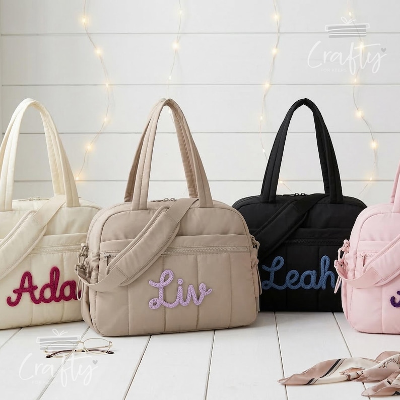 Puede incluir: Una colecci&oacute;n de bolsos tote acolchados personalizados en crema, beige, negro y rosa. Cada bolso presenta un nombre bordado en un color contrastante. Los bolsos tienen asas superiores y una correa para el hombro. Los bolsos est&aacute;n sobre una superficie blanca.