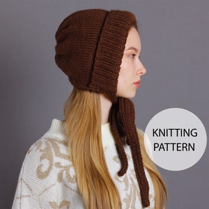 Peut inclure: Un bonnet en tricot marron avec une longue cravate. Le bonnet a une couronne arrondie et une bordure qui couvre les oreilles. La cravate est assez longue pour être nouée sous le menton. Le bonnet est porté par une personne aux longs cheveux bruns. Le texte "KNITTING PATTERN" est visible sur l'image.